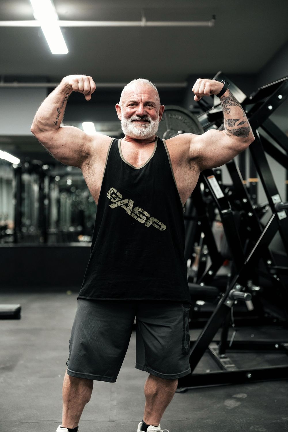 Tony Barnbrook, front double biceps in the gym — the comeback physique at 55